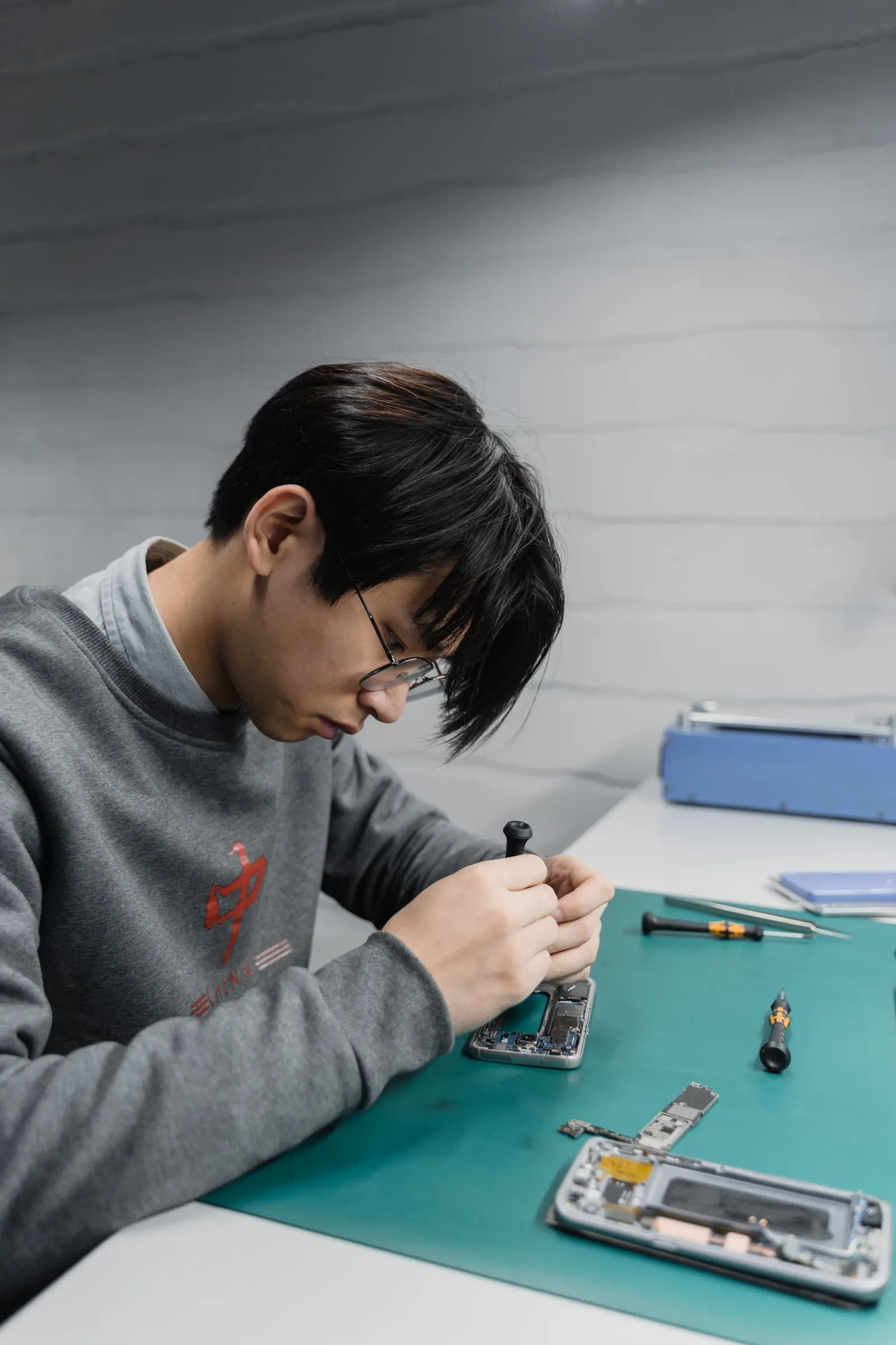Technician repairing a smartphone at the bench