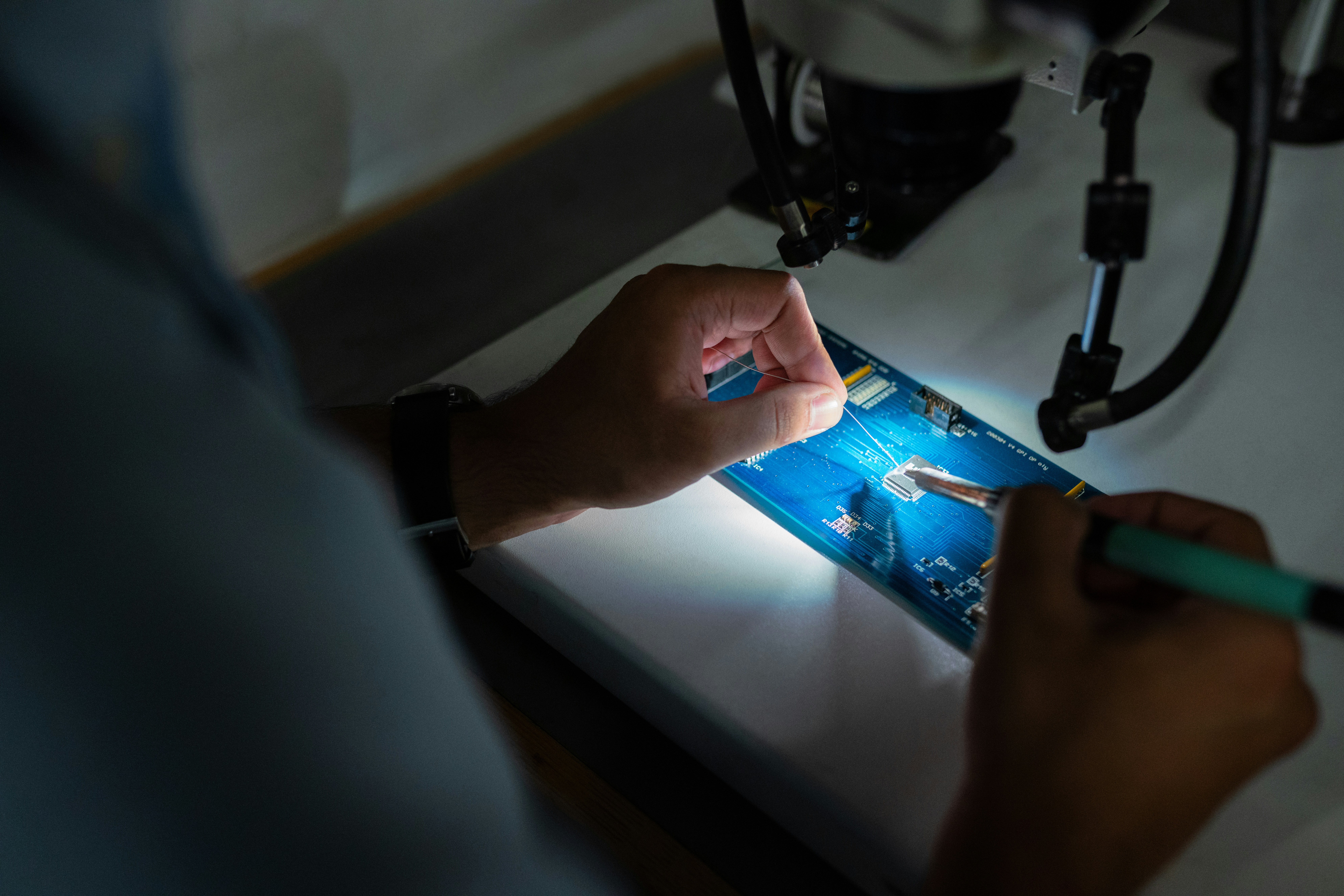 Technician examining phone internals for liquid damage indicator sticker, Kota repair shop